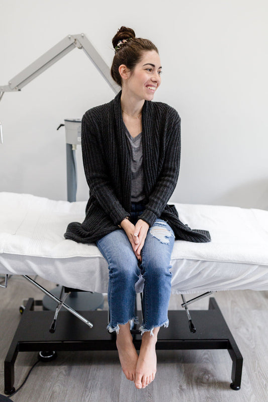 Woman sitting on a treatment bed smiling